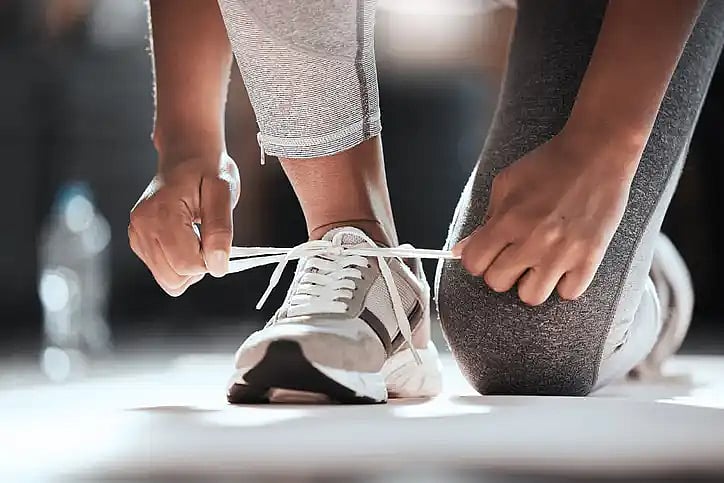person tying their shoes and getting ready for exercise advice