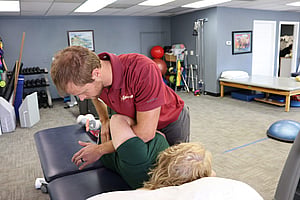 Advantage Rehab therapist in Powell Wyoming using body weight and manual therapy to manipulate the patients spine and release tention in the back and hip